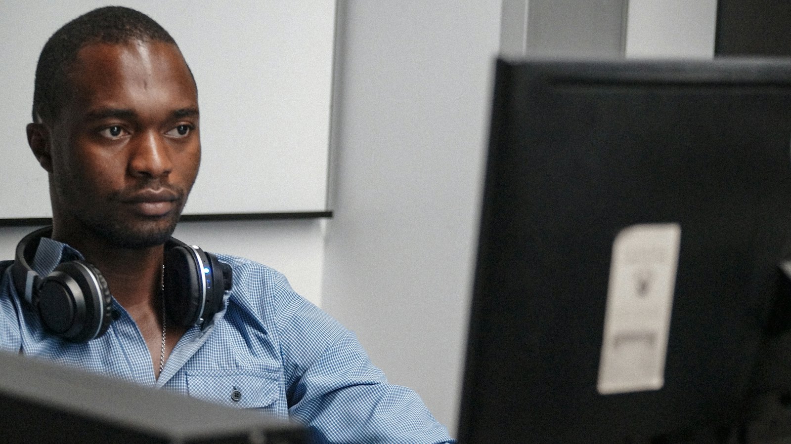 An engineer with headphones working at a computer