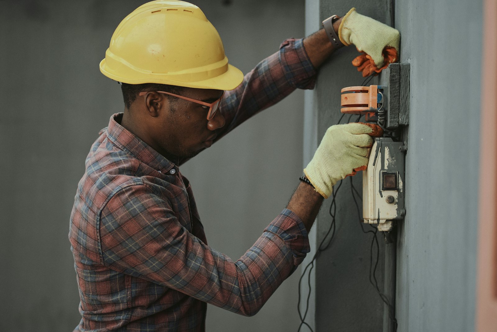 An engineer in a hard hat working on an electrical installation