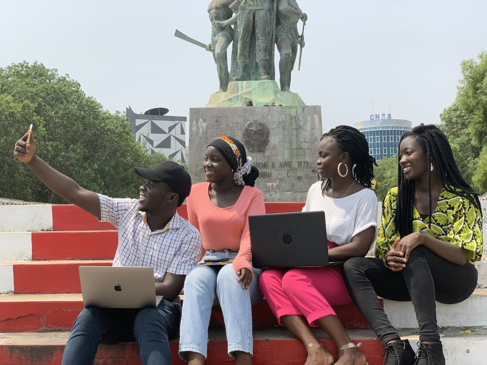 Young people working together on laptops outdoors