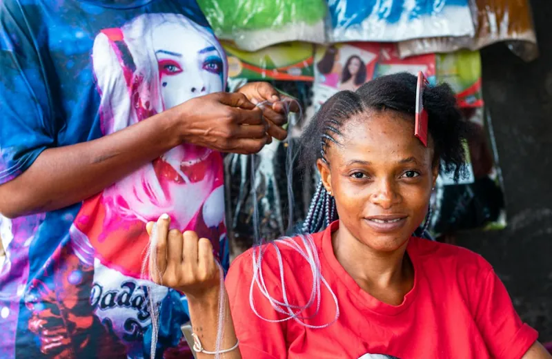 A customer having her hair braided at a salon